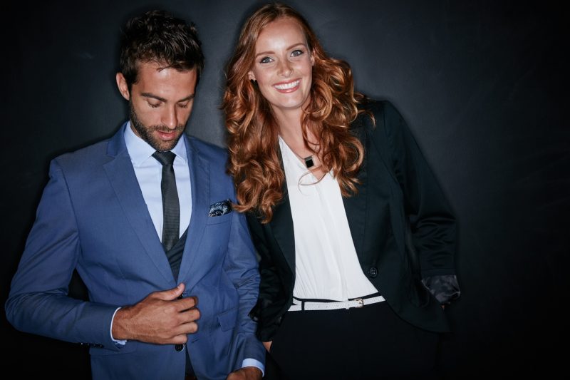 Studio shot of a young couple standing against a dark background